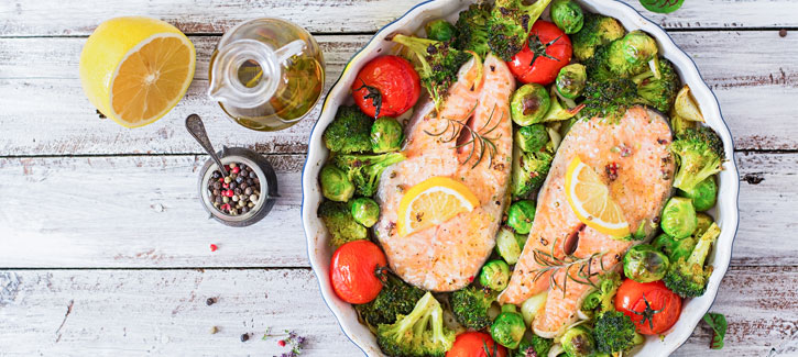 Verse zalm met spruitjes, broccoli en tomaat uit de oven