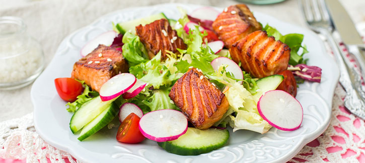 Salade met gebakken zalm, radijsjes en tomaat